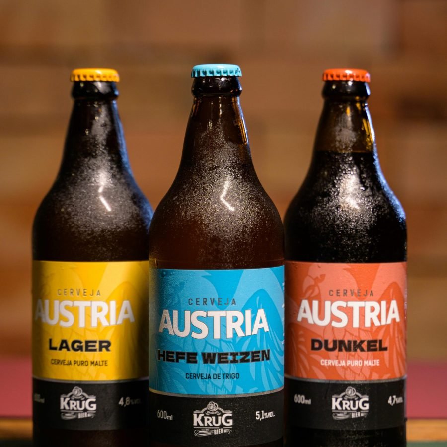 Three chilled Austria beer bottles showcasing Lager, Hefe Weizen, and Dunkel varieties.