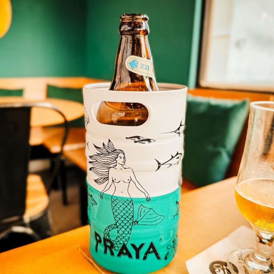A Praya beer bottle in an artistic holder on a Rio cafe table, captures the laid-back vibe.